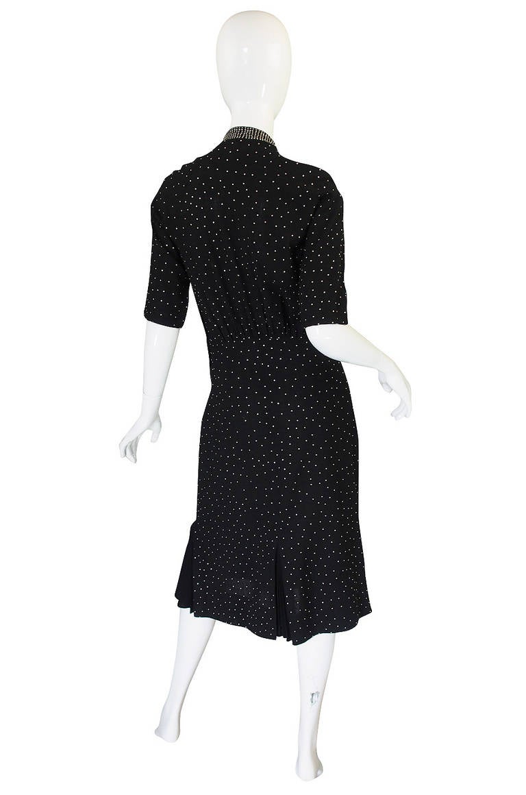 These studded dresses from the 1940s are almost impossible to find and often examples have just a touch or detailing of stud work. This one however is like the holy grail as it is completely covered in hand set silver studs with a denser application