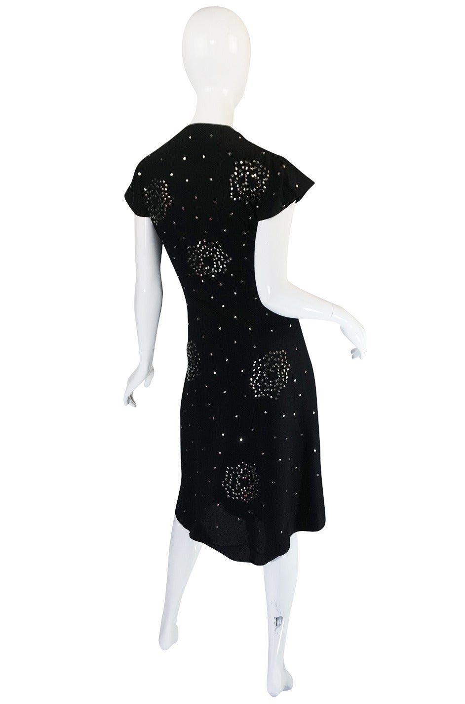 These studded dresses from the 1940s are almost impossible to find and often examples have just a minor detailing of stud work. This one however is like the holy grail as it is completely covered in hand set, flat almost sequin like, silver studs