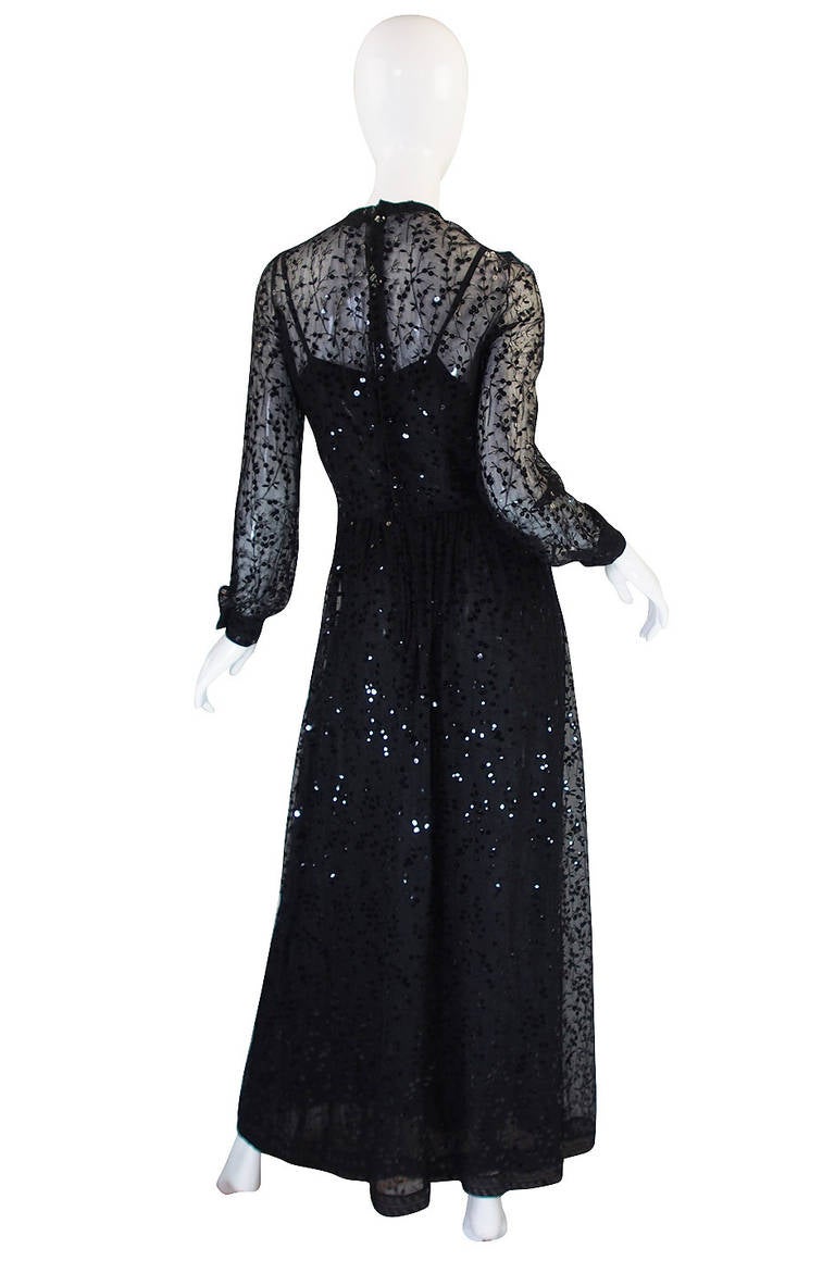 This is a very fine Chanel dress that is densely covered with black sequins and beautifully made. Both the interior of the gown and the exterior are made of a fine black silk. Then the black silk chiffon outer layer has a hand embroidered design