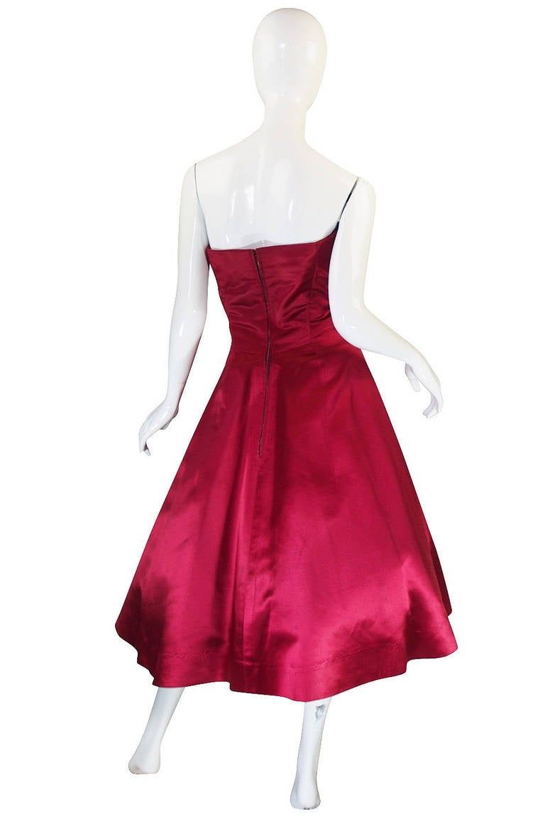 This is an incredible numbered Christian Dior from the 1950s. The color is a deep red that seems to glow from within with its own light! It is hand dyed on a fine ribbed silk satin that is very beautiful. This is classic Dior and based on the 