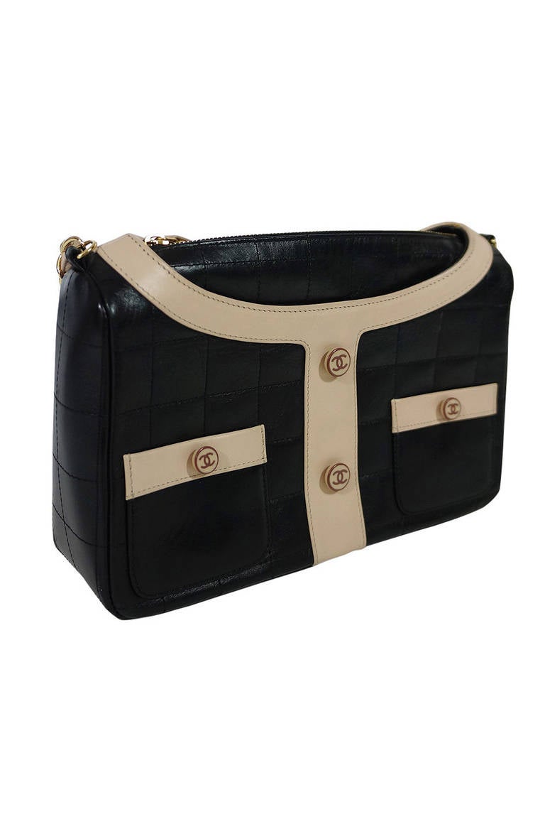 This rare, limited edition 2002 Chanel bag mimics the classic & iconic Chanel jacket! The leather is top stitched into perfect little squares. Two adorable pockets sit on the from and each is actually functional! Four logo buttons add to the