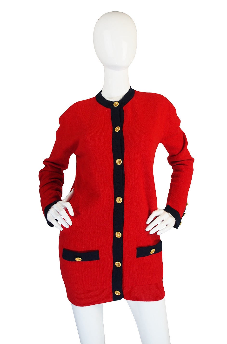 This is a fantastic Chanel 100% cashmere cardigan that is a classic basic that has been done is a beautiful red with navy stripe detailing and will never go out of style. Made of the finest cashmere in the world, it is luxurious and feels amazing