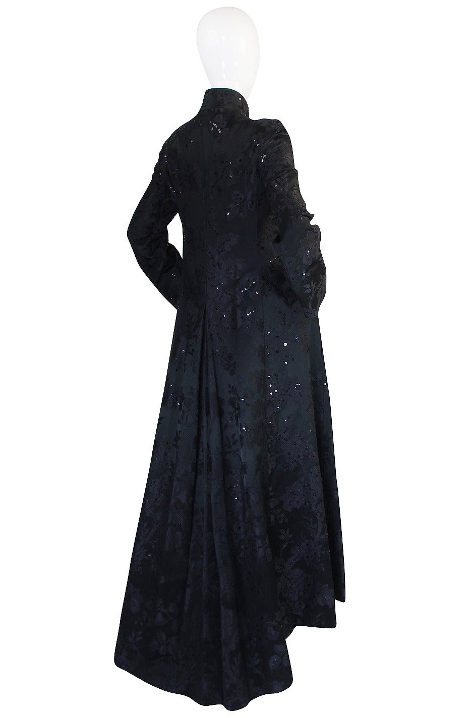 Phenomenal black silk opera or evening coat that was certainly a custom piece. It is exquisite in its cut and design with the simplicity and stark lines allowing that beautiful silk brocade and brilliant cut to take center stage. The fabric is a