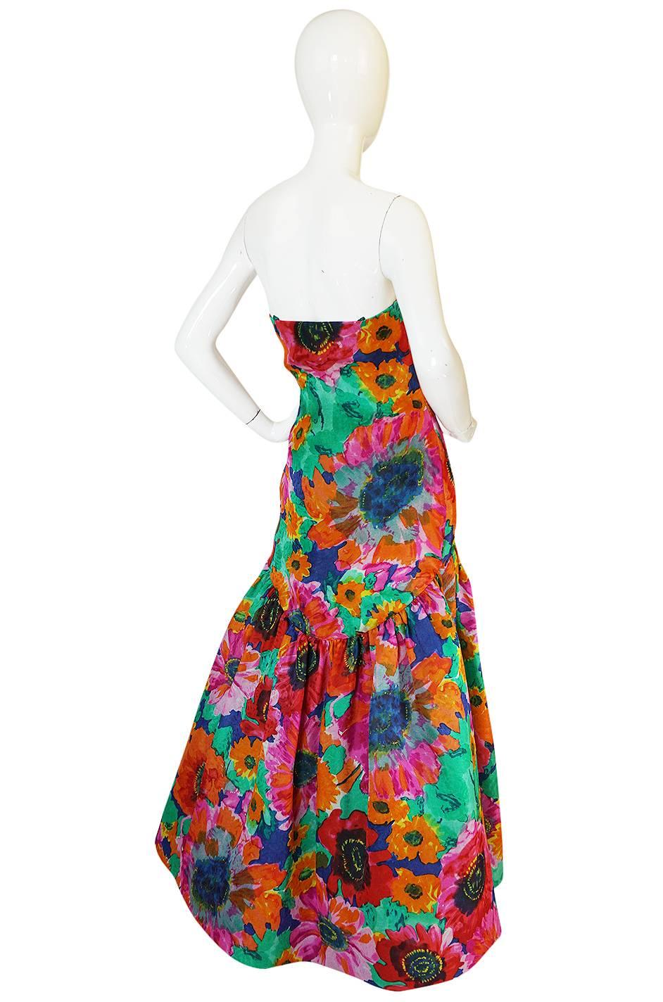 

Yards and yards of brilliant floral silk gazar have been used in this Arnold Scassi gown. Scaasi studied under Charles James and you can see that influence heavily in this particular piece. This piece has the added bonus of having a dated tag