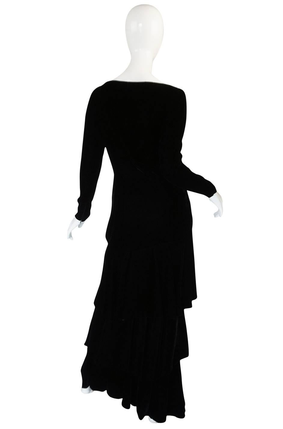 

A luxurious, rich black velvet maxi dress has a stunning long and slim cut accented by a wonderful tiered skirt and side plunging neckline. This gown by Lanvin is stunning in its simplicity and the richness of the velvet adds to that. I am so
