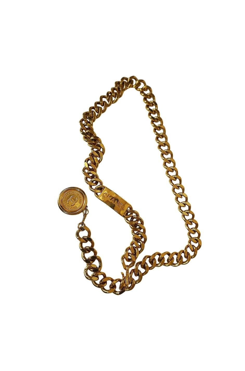

Love this weighty gold chain belt from the 1990s. It's the perfect piece when you want to add a bold statement. It wraps and hooks around the waist and has a dominant ID plate with Chanel engraved into it. At the end of the chain that hangs it