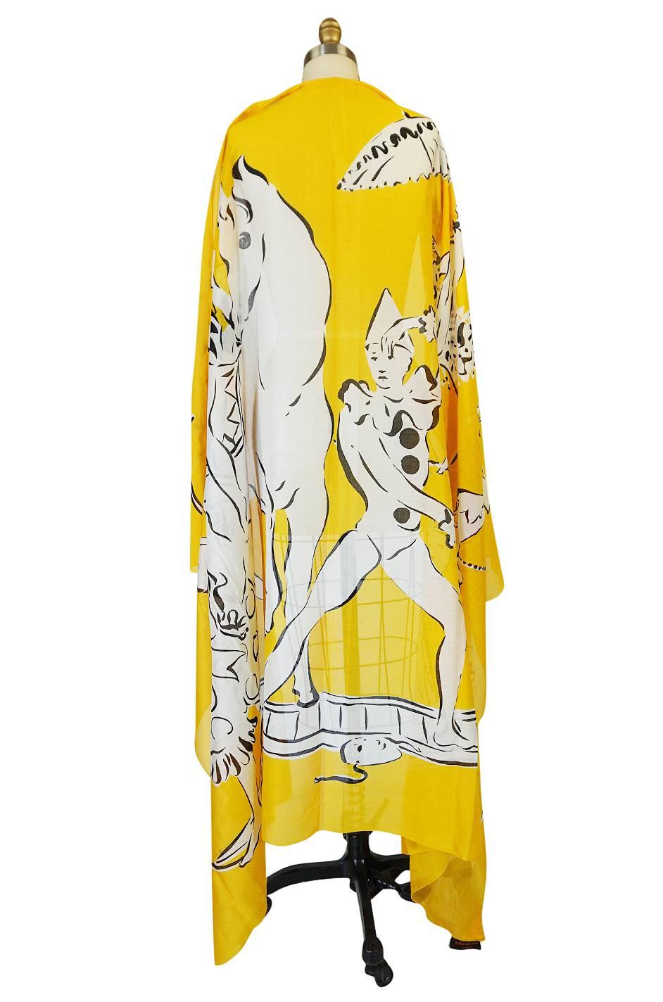

Gorgeous and absolutely huge, this Yves Saint Laurent scarf is a mix of a yellow backdrop with a white and black circus design that is insanely beautiful and detailed. The fabric is 100% cotton voile and light and airy with just a touch of