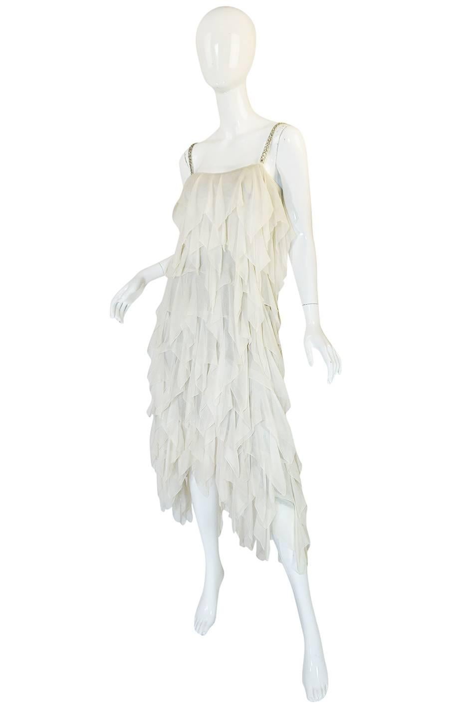 

This wonderful Stavropoulos dress is an absolute extravagance of silk chiffon tiers. It is made from layers and layers of a beautiful ivory silk chiffon crepe all stitched onto an underlay of a silver lame fabric so you get just the glimpse of