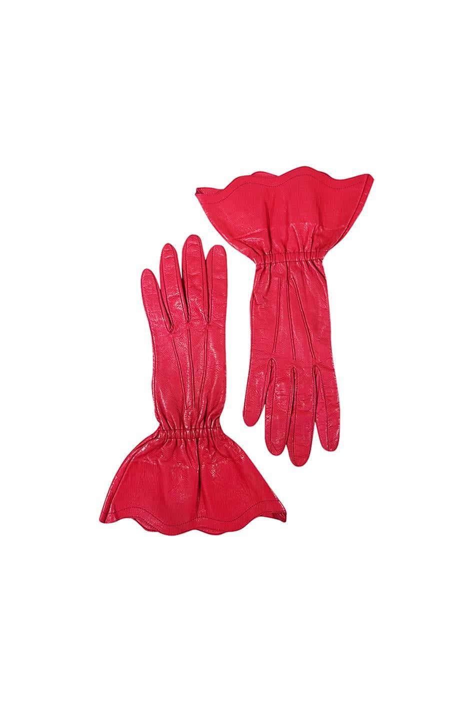 

A spectacular pair of gloves by Yves Saint Laurent that are made from the finest lightest kid leather that has been hand dyed to a brilliant true hot pink color (they are a true bright pink in person). They are lightly lined which allows them to