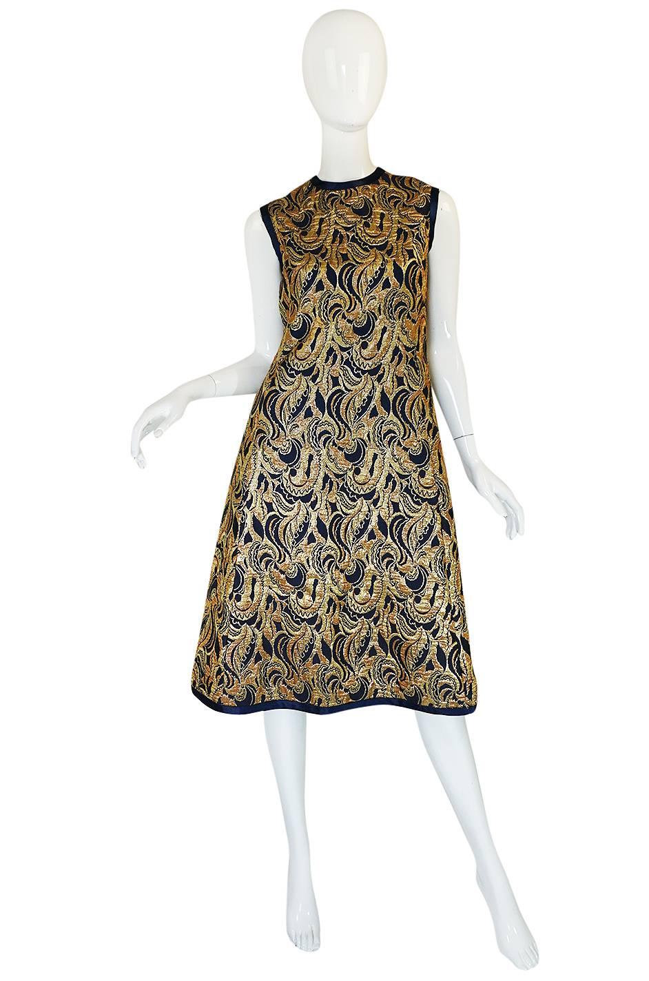 

This is an absolutely gorgeous Malcolm Starr dress & jacket that has been made out of a wonderful metallic fabric with hues of gold and copper swirling over a navy base. The dress has a very simple and easy to wear cut that is classic Malcolm