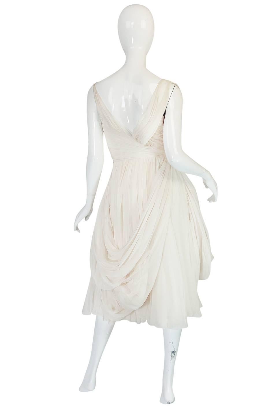 This is a wonderful little dress in the manner of Jean Desses. It unfortunately does not have a label so I am hesitant to attribute it to his work though it may be a ready-to-wear piece. Given its design and lines it certainly could pass as one and