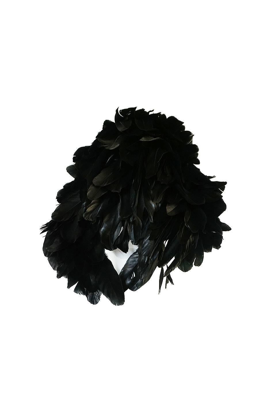 This hat is such a statement piece and so bold. It is made of a glossy, iridescent black feathers that are all set to sweep back front he front and give it that wonderful fullness. It is almost like a hood and the effect is marvelous. It is