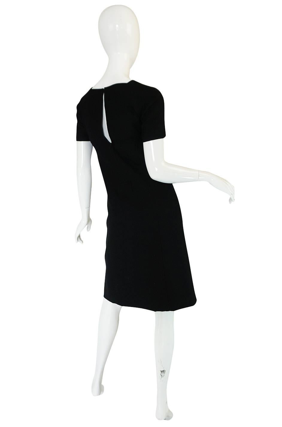 I have had the twin of this dress in the past and its as good now as the first time. This is a fabulous little black Courreges shift dresses and it is one of his classic designs. The fabric is jet black, light wool with a fine ribbed texture running