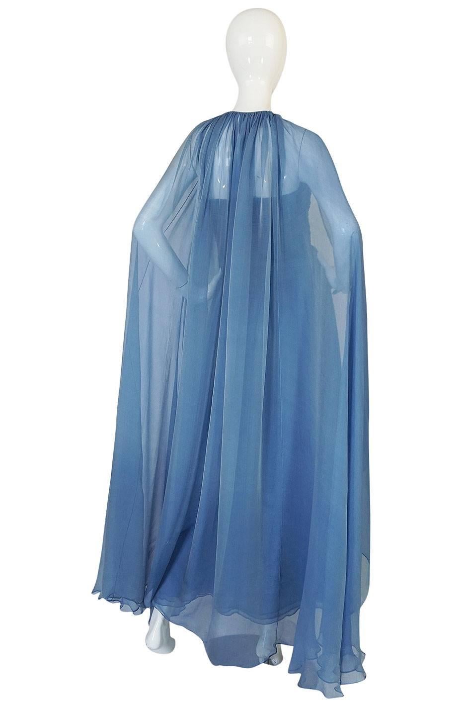 

This is a beautiful and romantic bias cut silk chiffon dress with a matching full length cape by the great American couturier Oscar de la Renta. Both pieces are constructed from layers of a lightweight, slightly textured, silk chiffon in the