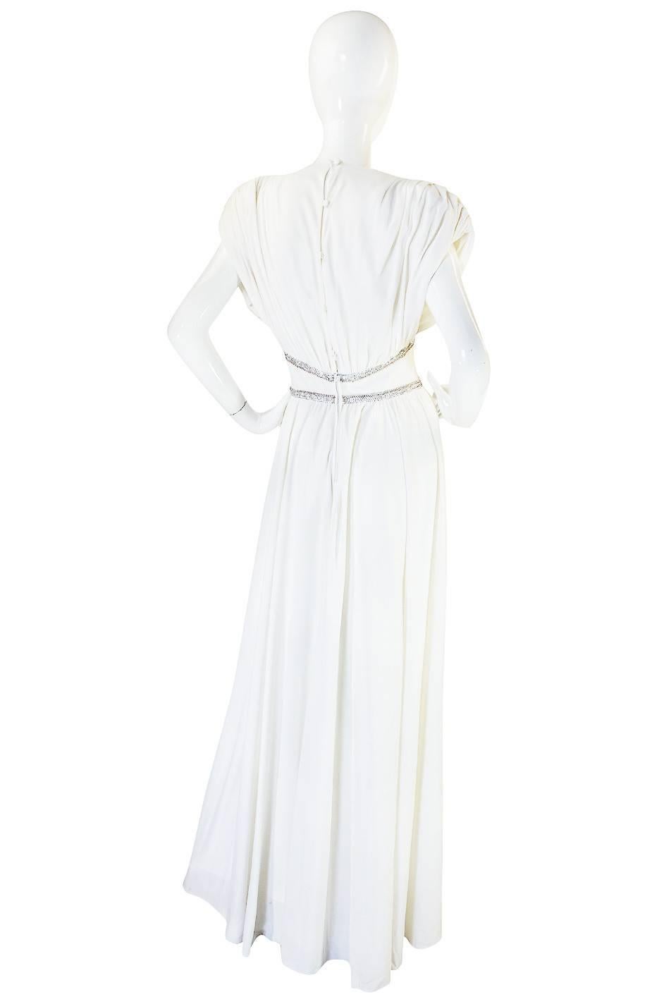 Supermodel length and made of yards and yards of a fabulous white jersey that drapes and moves divinely, this Frank Usher dress will make you feel like a Grecian Goddess. Everything about it feels like it belongs on the red carpet and it has a