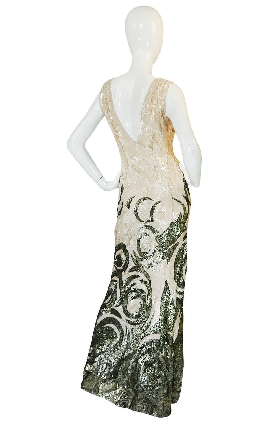 This is an exquisite late 1920s, perhaps early 1930s sequin and net gown. The exterior of the dress is entirely covered with tightly spaced, hand applied sequins in cream and a gold. It is one of the most spectacular gowns from this period I have