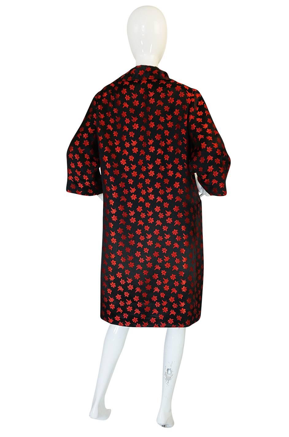 This matches the dress listed today and is a beautiful 1950s swing coat. It is made from a very fine, high end silk. The silk has a beautiful red thread woven through and used in the black silk base to create the beautiful little floral designs