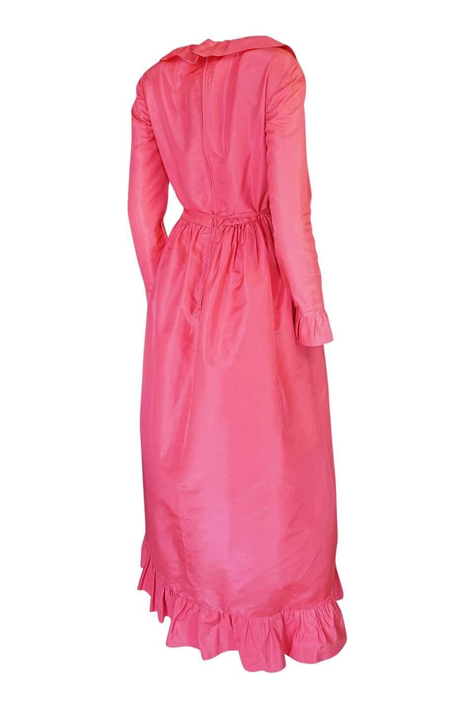 This silk taffeta gown by the Mollie Parnis label has be made form a soft pink silk taffeta. The use of such a bright and unexpected color instantly make it a statement piece. The cut is simple but the ruffled details give it pop. At the neck a