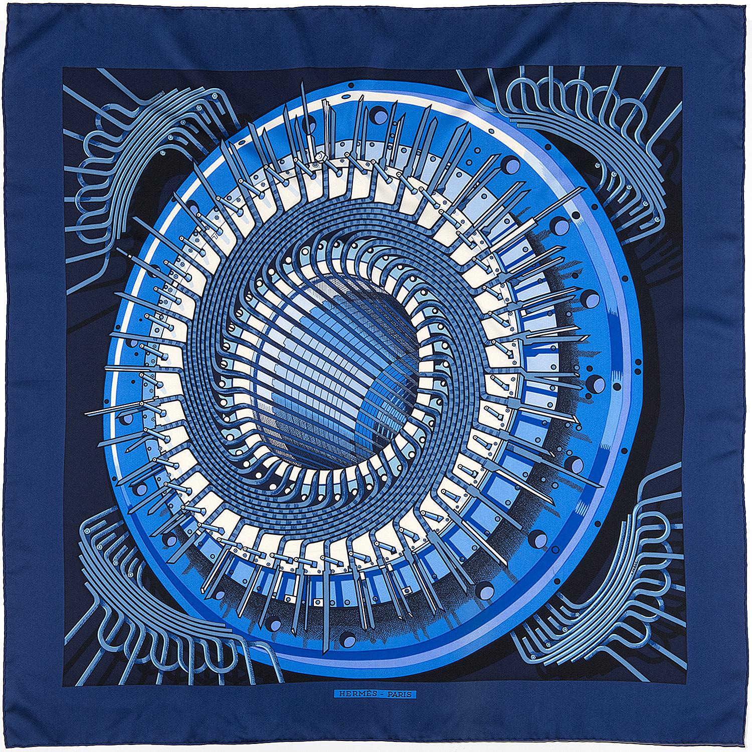 A Stunning Hermes Silk Scarf in Pristine, As-New condition. 'Alternateur' by Pierre Peron was first designed in 1971 and re-issued in 2012. This beautiful design finished in rich blue hues, is from 2012 and is a real statement piece.