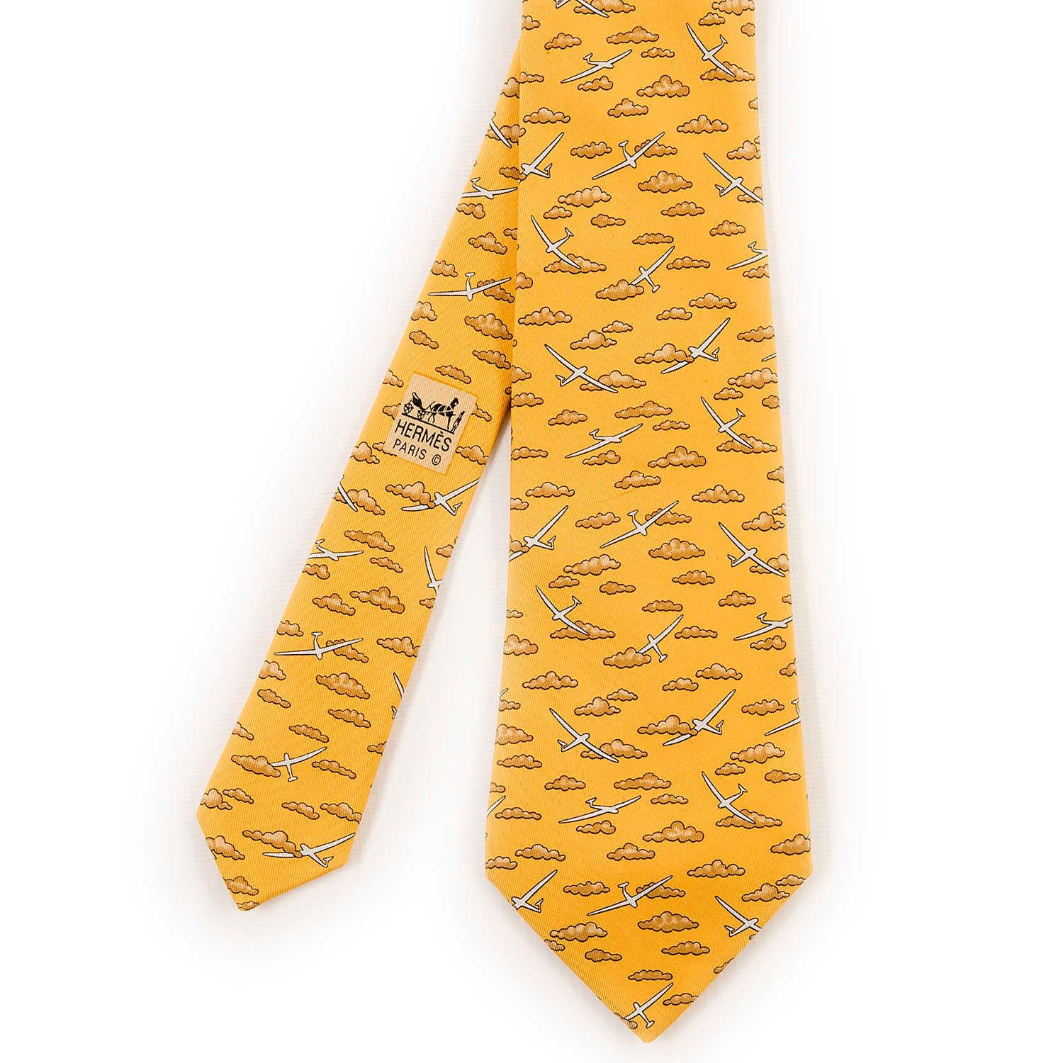 In pristine condition, this delightful Vintage Hermes Silk Tie, 'Gliding' has a whimsical design of Gliders and Clouds. The Tie is on a Sand yellow colour ground.