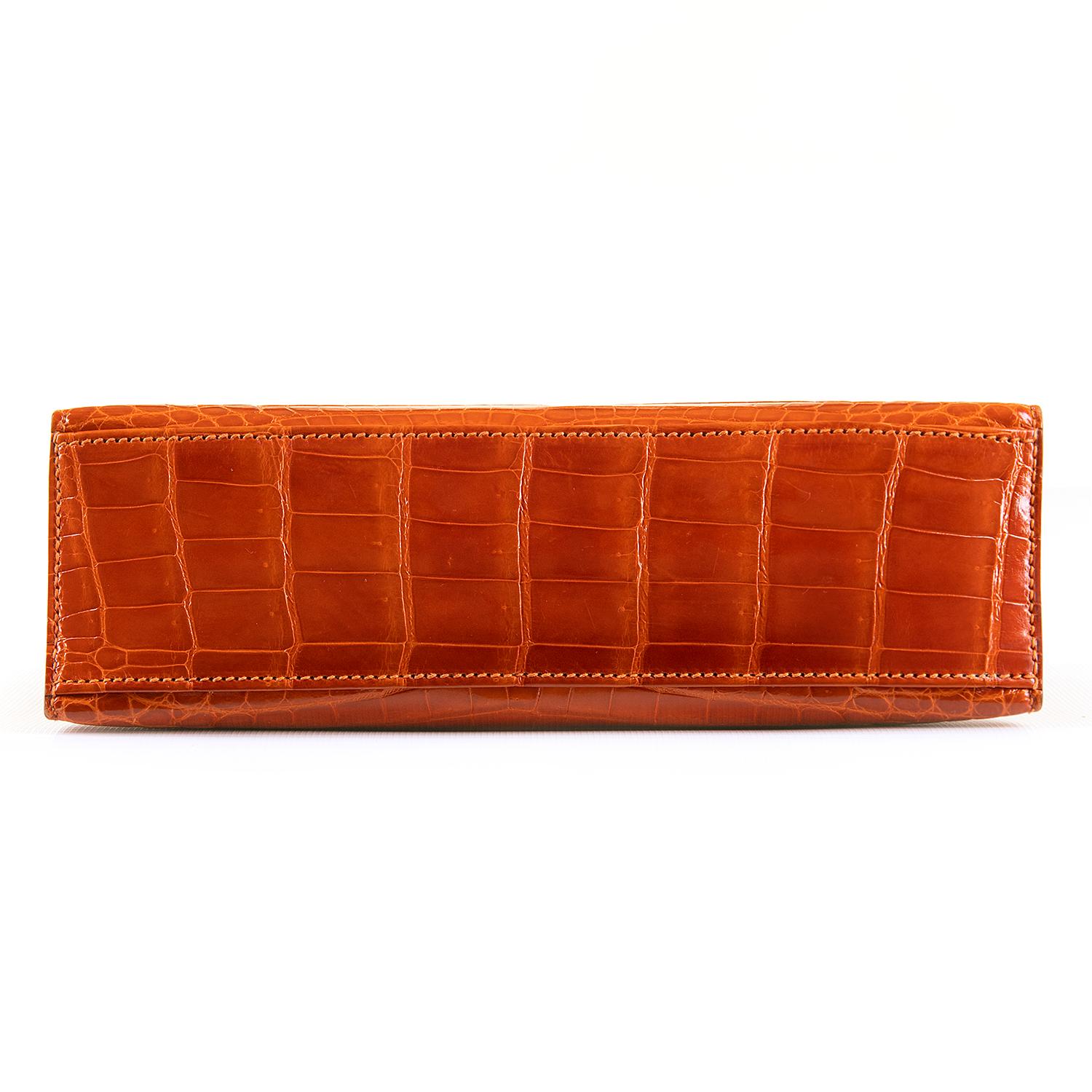 In absolutely Pristine, 'As New' Condition, this rare Hermes Mini Kelly Clutch Bag is finished in beautiful Orange Nile Crocodile, accented with Silver Palladium Hardware.  This top of the range Hermes bag comes complete with it's original Hermes