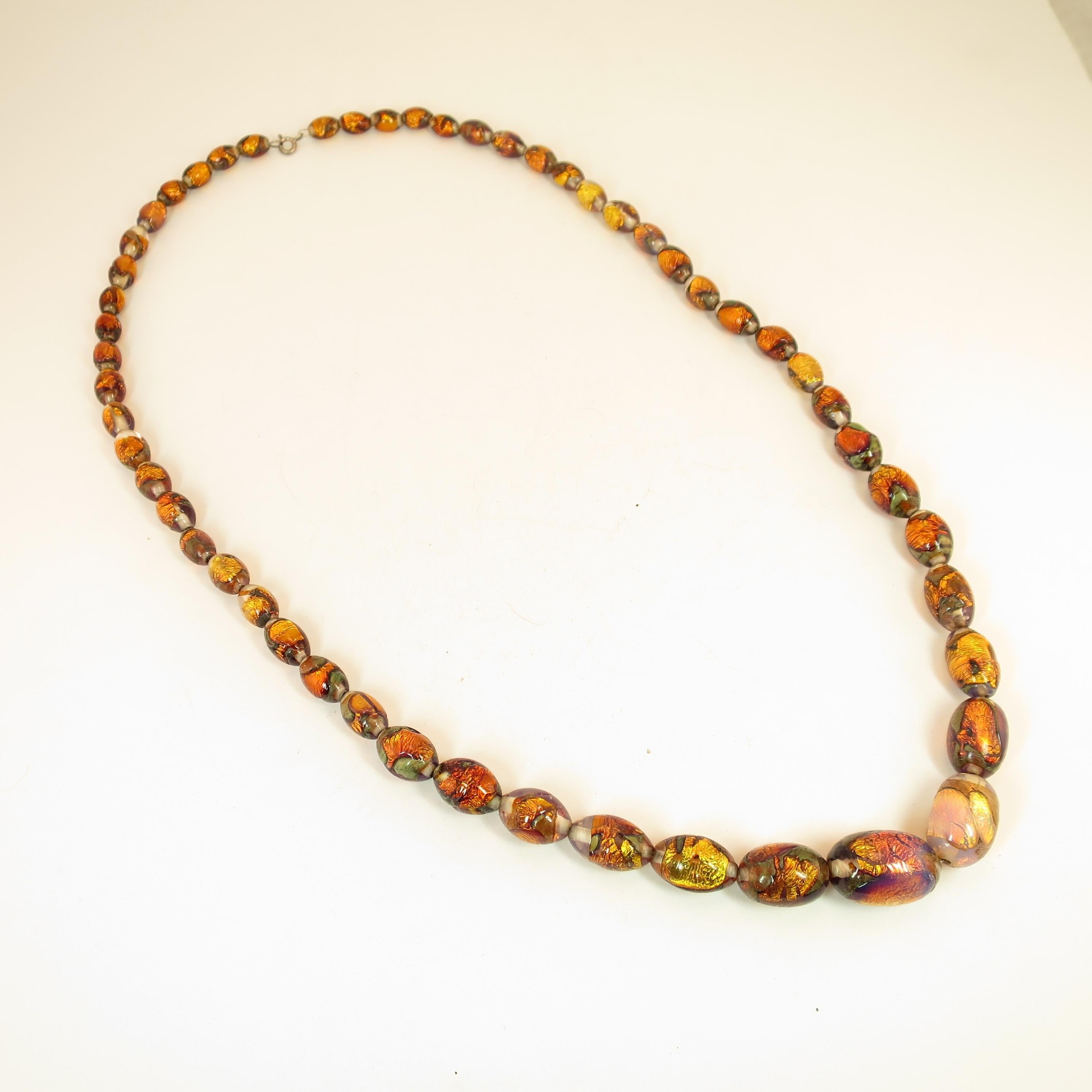Offered here is a 1950s beaded necklace of graduated hand-blown Venetian fire opal foiled glass beads in a variety of luminous opalescent hues, ranging from fiery lava-gold to intense iridescent blue-pinks to translucent pale opal. These dazzling
