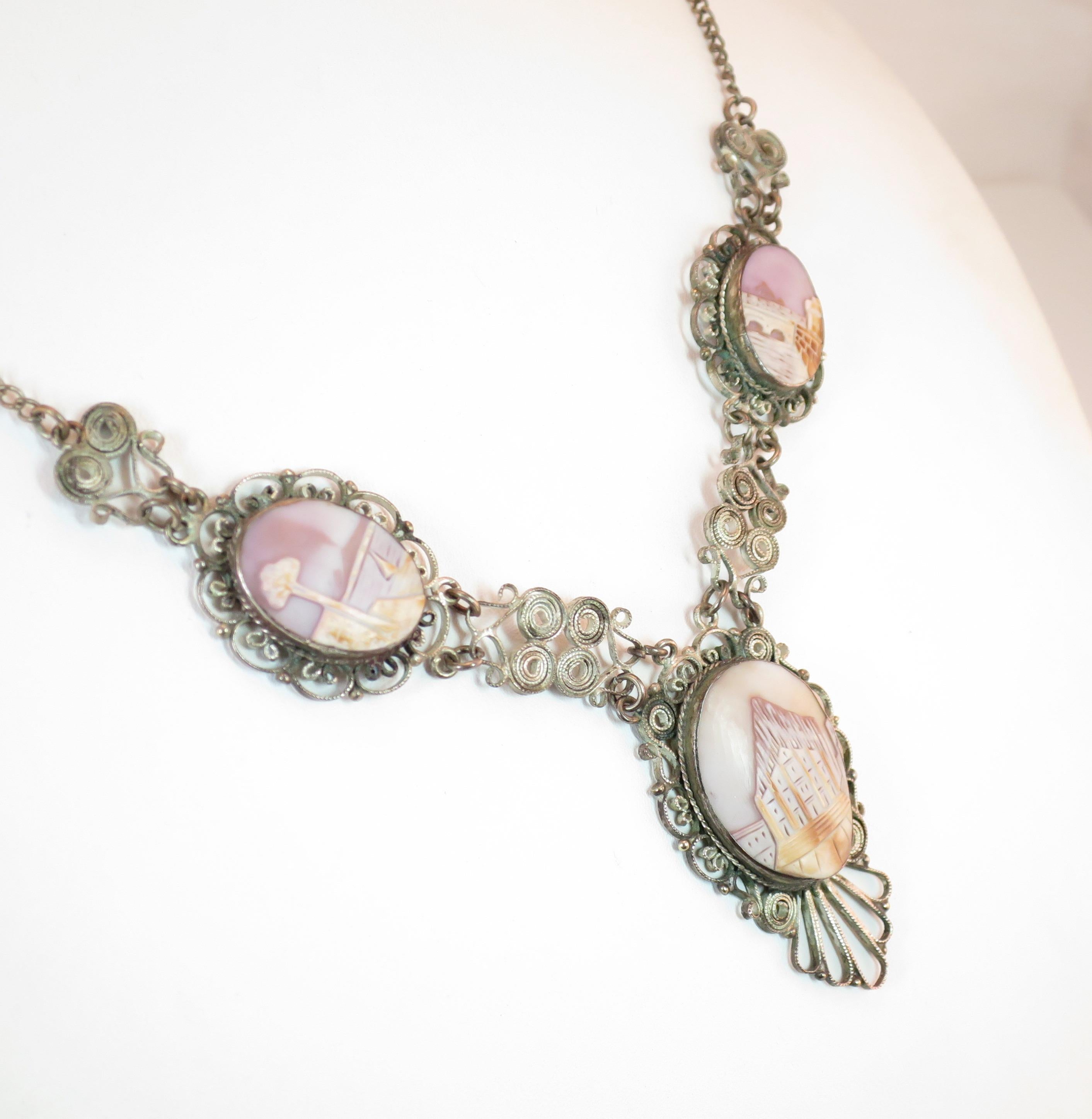 Offered here is a Victorian-style landscape shell cameo silvered filigree necklace from Italy in the 1950s. The central portion consists of three linked platforms in a filigreed open-back design linked by segments of flattened spiral filigree. The