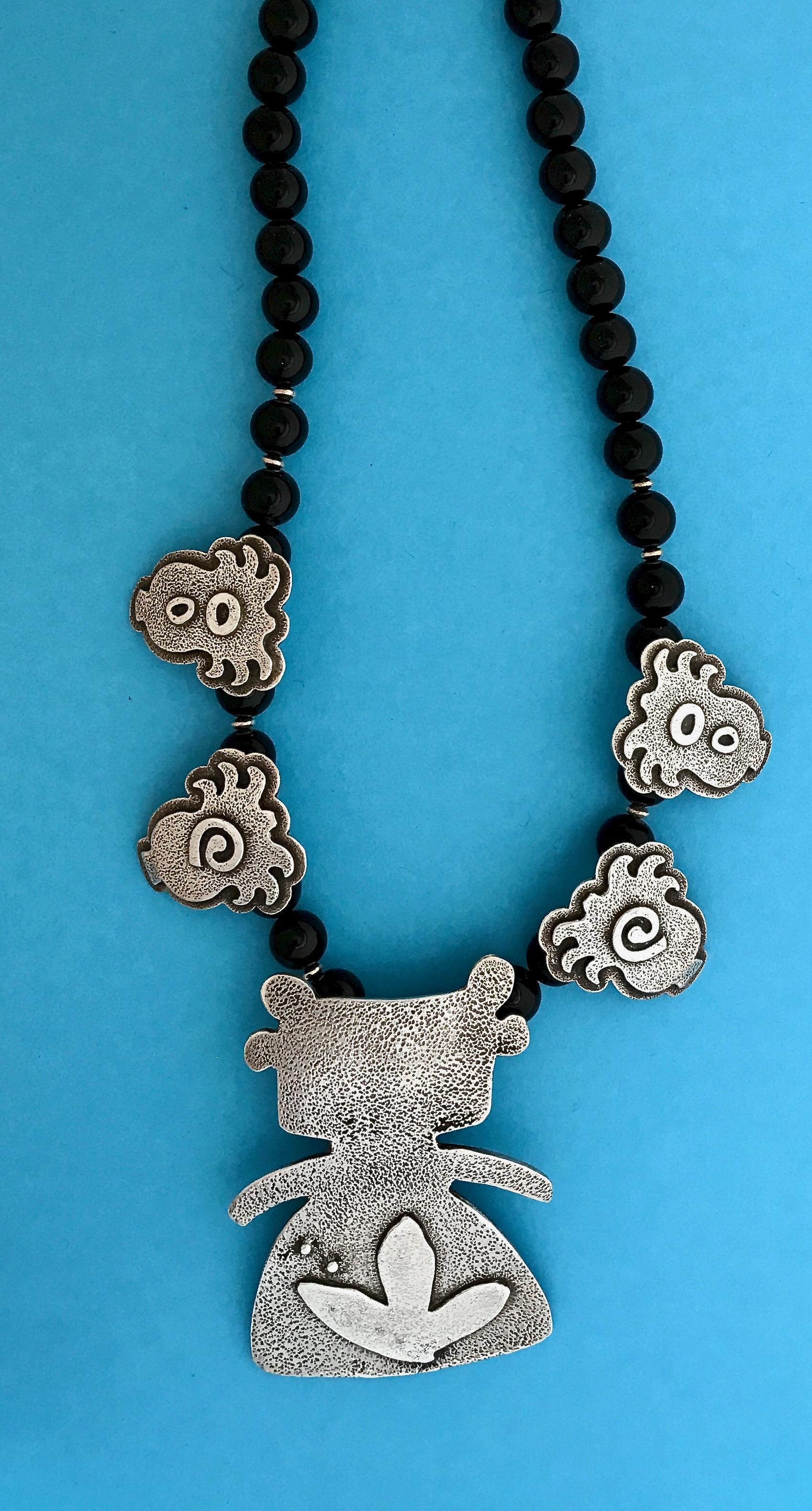 Morning Walker with Plants necklace, Melanie Yazzie cast sterling silver onyx

Melanie A. Yazzie (Navajo-Diné) is a highly regarded multimedia artist known for her printmaking, paintings, sculpture and jewelry designs.  

She has exhibited,