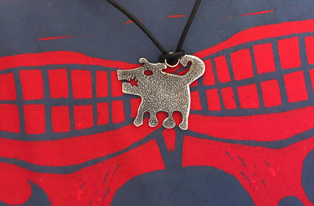 Sombra Girl, cast silver rez dog pendant, Melanie Yazzie, Navajo 

Melanie A. Yazzie (Navajo-Diné) is a highly regarded multimedia artist known for her printmaking, paintings, sculpture, and jewelry designs.  

She has exhibited, lectured, and