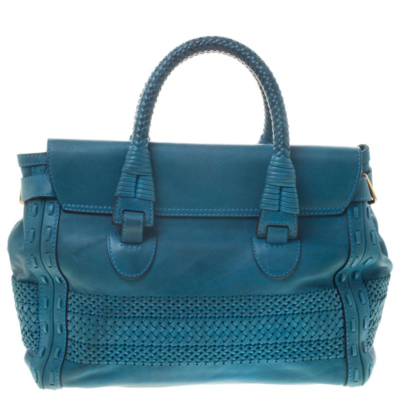 An exceptional play of leather trims, the 'Handmade' satchel from Gucci is an excellent blend of style and comfort. The blue bag features dual rolled top handles, lock closure at the front flap, leather charm, a padlock and a sturdy base. The canvas