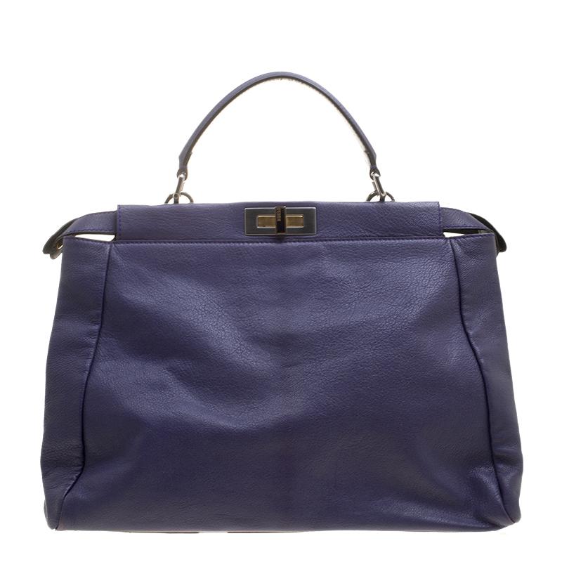 This exquisite Peekaboo from Fendi is highly coveted, and since its birth in 2009, it has swayed us with its shape, design, and beauty. This version comes meticulously crafted from purple leather and designed with a top handle and a shoulder strap