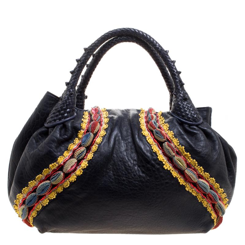 Part of Limited Edition, this Fendi Spy bag exudes a Boho-chic vibe- much trending amongst young fashionistas. It is designed in a dark blue leather and detailed with embroidery along the outer sides. It features a strap closure, two rolled top