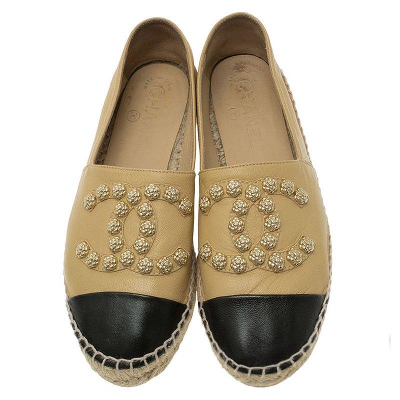 These comely Espadrilles by Chanel are truly winsome. Crafted in beige and black leather and jute trimmed soles, thy look stylish in camellia flower embellished CC logos at the toes. Wear them with casual jeans or fashionable trousers for a swank