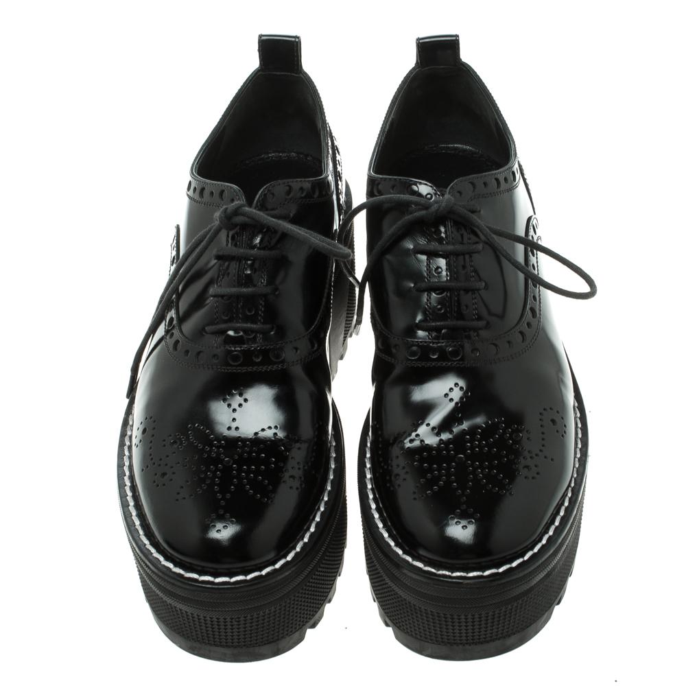 Louis Vuitton Black Brogue Leather Fighter Platform Oxfords. Classic brogue form upper in a combination of black leather and black synthetic patent. Shining style and contrast dotted trim detail with a lace up closure. Contrast black 8-inch high