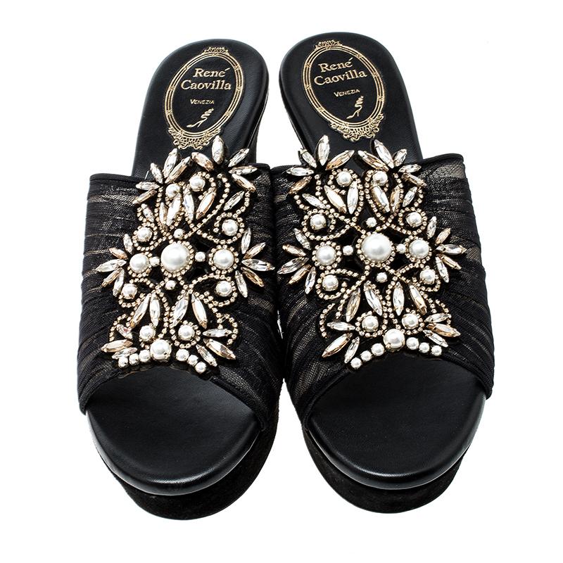 Coming from the Italian designer Rene Caovilla, these slides are perfect to style for any dressy occasion. Set on a wedge sole, this pair is easy to slip on and off and feature a peep-toe silhouette. It comes with a black ruched tulle body and a