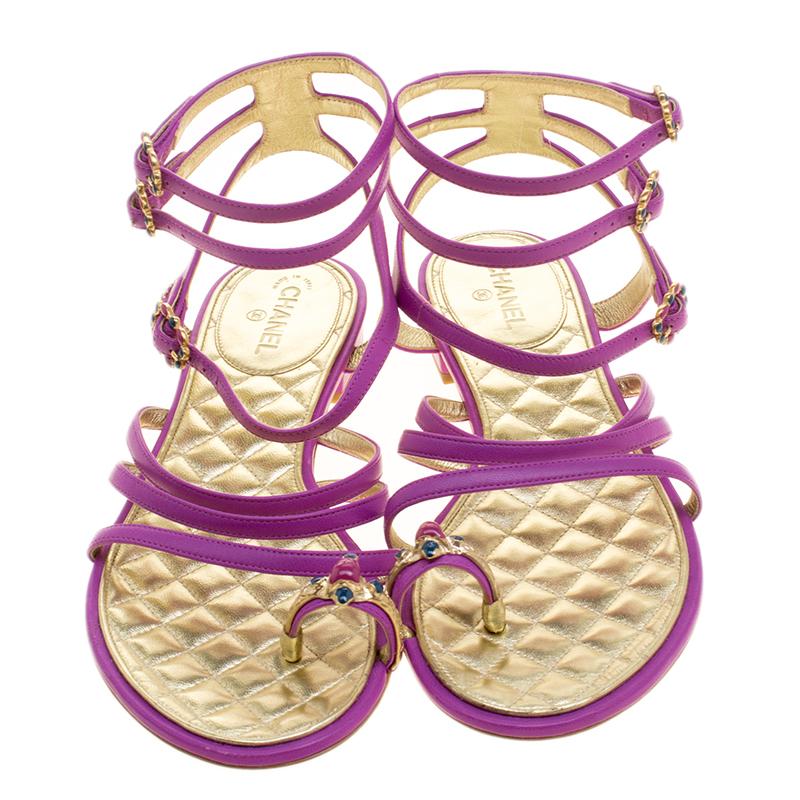 Your casual and day time wear summer shoes can look stylish and elegant just like these stunning Chanel flat sandals. Constructed in purple strappy leather design, these sandals feature gold tone hardware buckles through the ankle and front straps