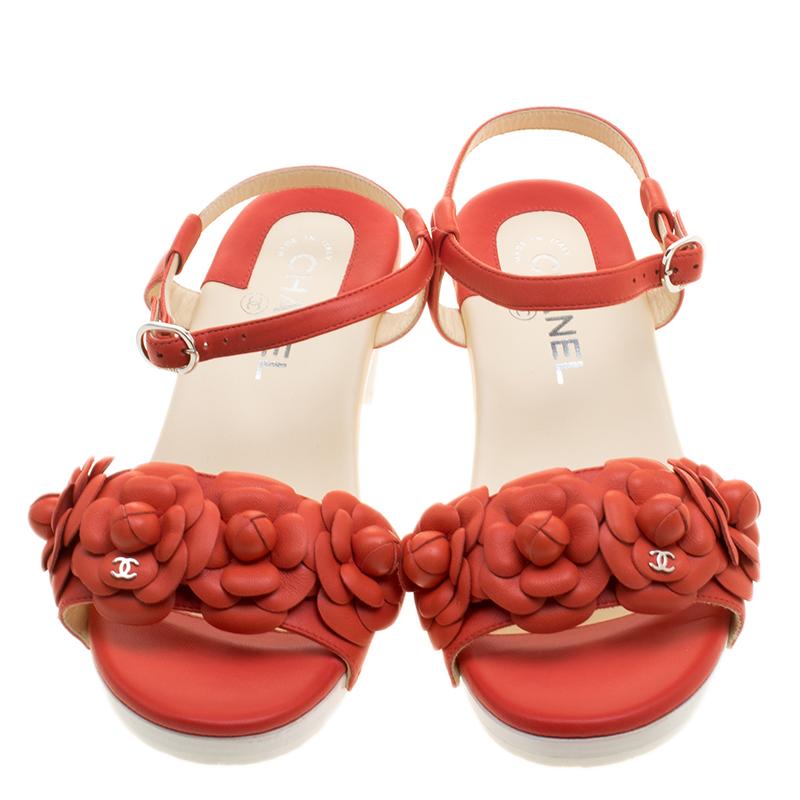 With a pop of colour that is perfect for the spring summer season, these Chanel ankles strap sandals are elegant for the day time along with day long comfort. Crafted in orange leather with camellia flower embellishments along the front strap these