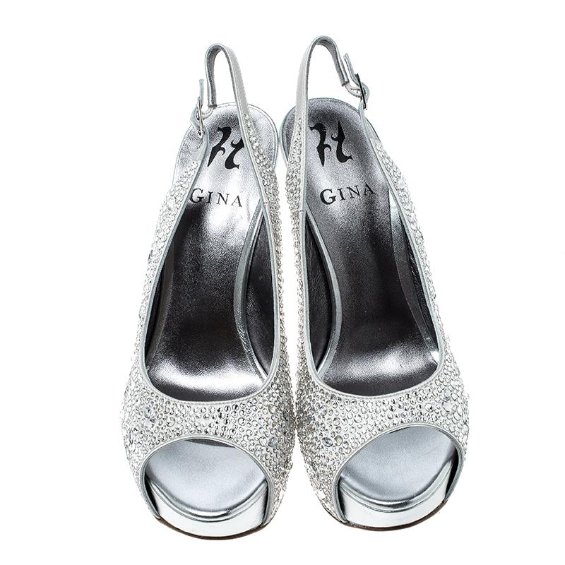 Coming from the house of Gina, these sandals feature a grey satin body with crystal embellishment all over it that makes it apt for those celebratory occasions. They are set on towering heels balanced with a platform sole and comes with a slingback