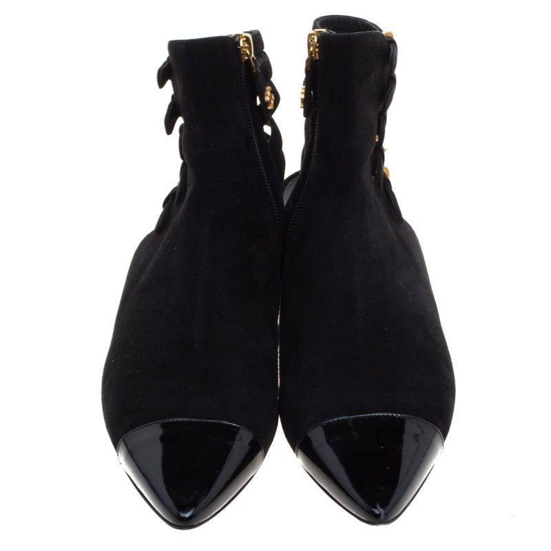 Purposely built to make you feel like a fashion diva, these Chanel flat ankle booties are not to be missed. The black beauties are crafted from suede and feature leather cap toes. They flaunt multi straps with gold tone buckle fastenings at the back
