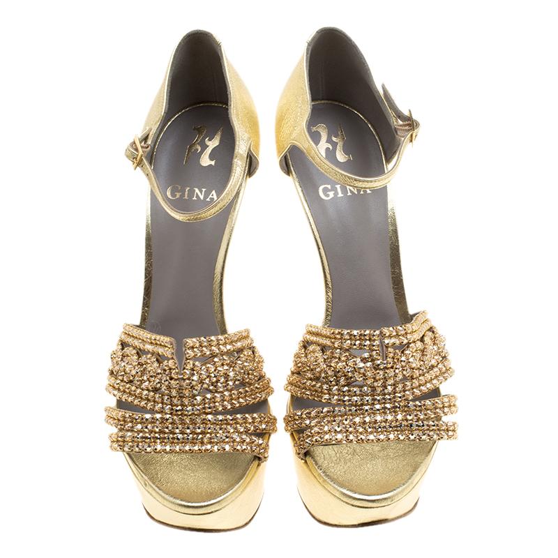 Create the most stunning and eye catching evening looks wearing these beautiful and glamorous Gina Sheridan ankle strap sandals. Designed in metallic gold leather and accented with crystal embellished straps all through the front, these shoes are