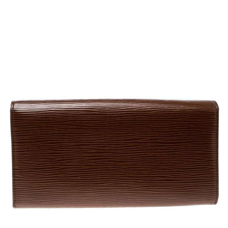 This cute and functional Sarah wallet by Louis Vuitton helps you organize your bills, cards and currency effortlessly. Having a luscious epi leather exterior, this wallet features a snap flap closure, six card slots, one large zipped coin pocket and