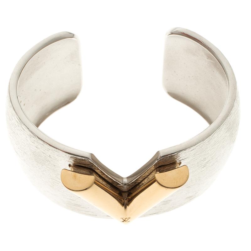 Designed by the luxurious fashion house Louis Vuitton, this Essential V Colorama open cuff bracelet is a versatile and fun piece to own. Constructed in silver tone metal, this cuff features a texured surface and a V cut detail at the front which is