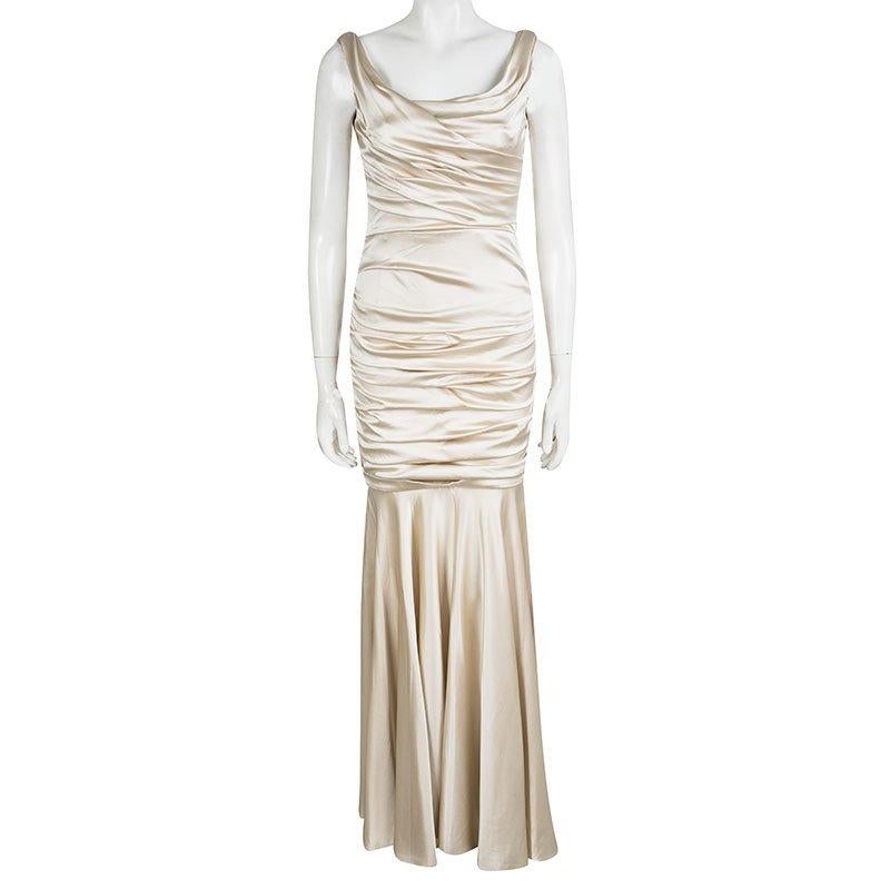 It's time to cast a spell and make others go gaga with this flawless gown from Dolce and Gabbana. The sleeveless gown in a shimmering beige shade is made of a silk blend and features a satin ruched silhouette with pleat detailing. It comes with a