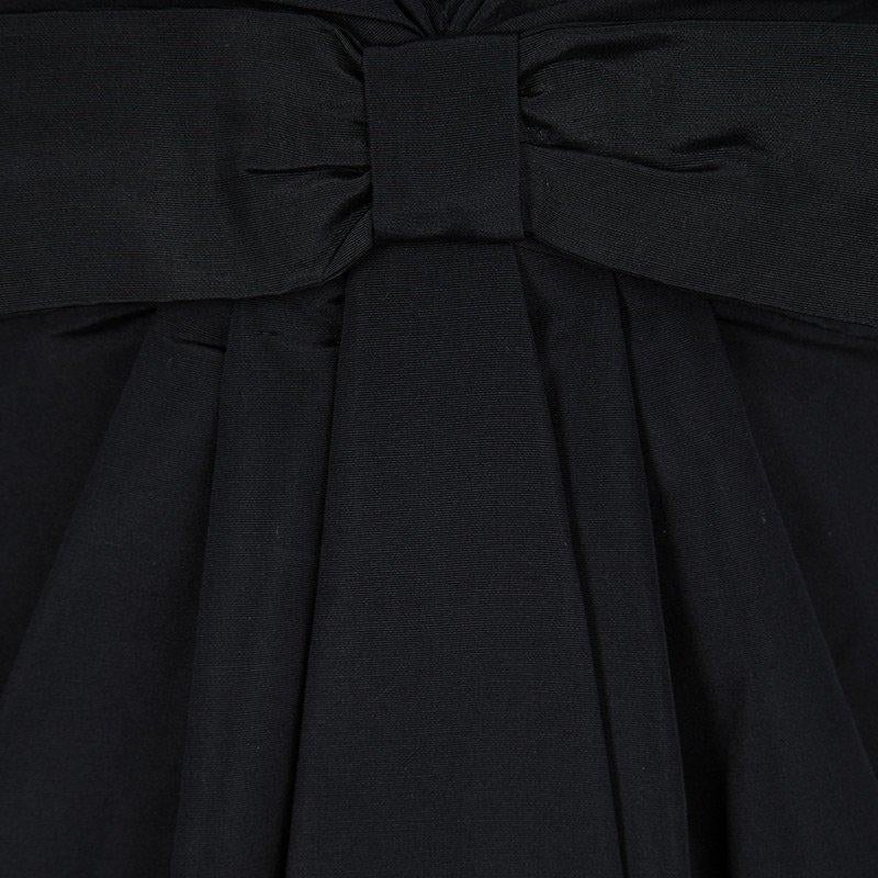 Elegant and classy, this is one dress that every woman dreams of having. Beautifully made from cotton and silk in Italy, this Valentino sleeveless dress has a lovely black hue, a plunging neckline and a bow at the front. It also has a calf-length