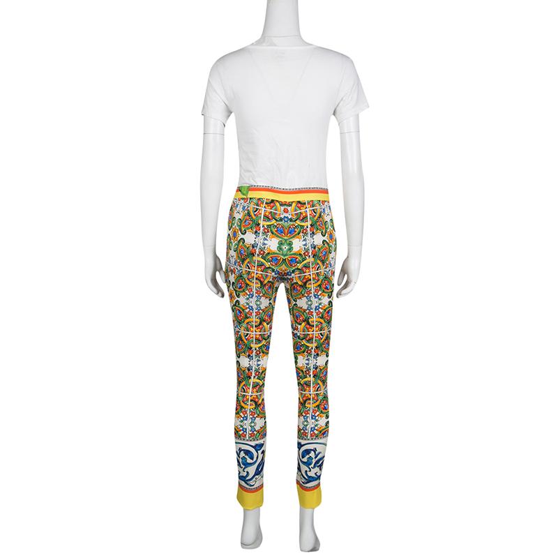 Cut from silk with hints of stretch, these Dolce and Gabbana pants, flaunting multicolored Majolica prints, are your go-to piece for any casual outing. They are designed with tapered legs and are secured with a zip fastening. Team them with a solid