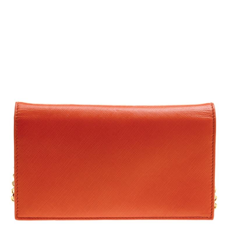 Crafted from leather, this orange Salvatore Ferragamo WOC has a style that will catch glances from a mile. It has been designed with a flap that reveals a satin interior and it is held by a chain. The sweet Vara bow on the front adds to its beauty