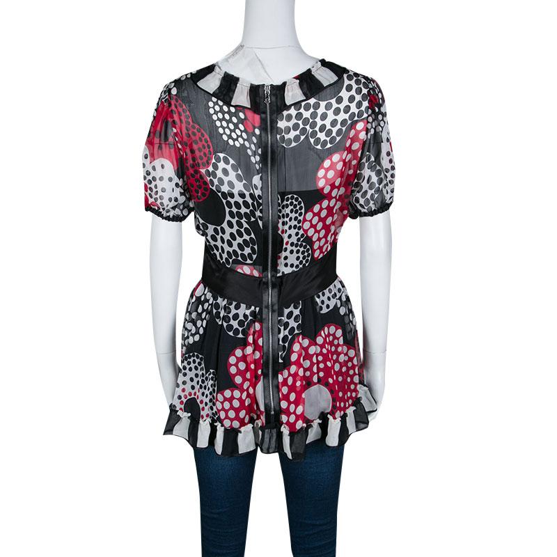 Add a touch of ruffles to your outfit for a feminine look with this Dolce And Gabbana silk top. Designed with a lovely shape, this multicolored top features polka dot pattern, a V neckline, short sleeves and black silk strap at the waist. The top