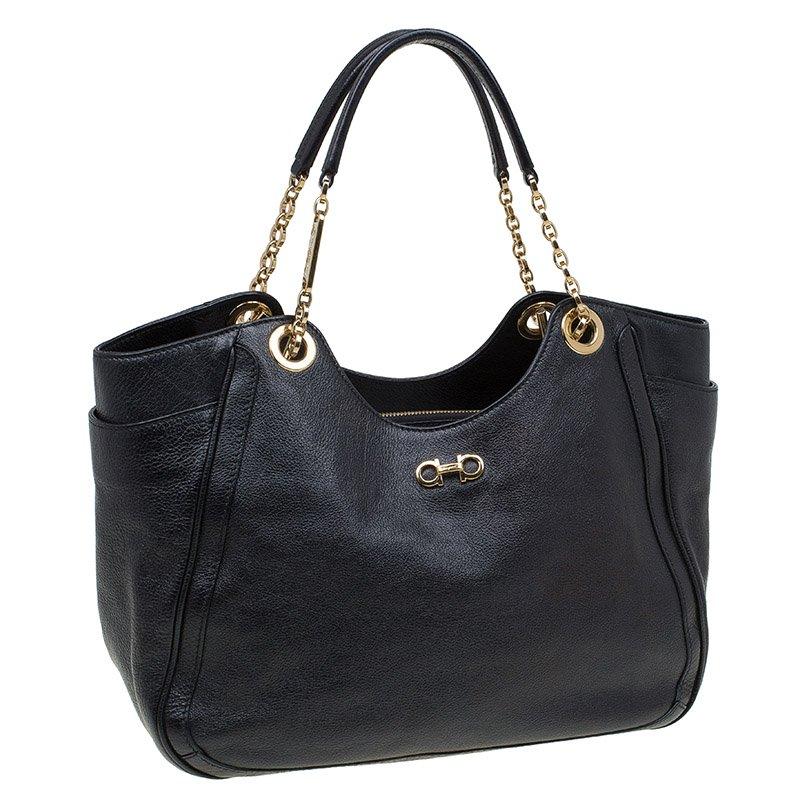 Ferragamo’s Betulla tote is elegantly styled without compromising on storage. Besides a roomy main compartment, it also has slip pockets on the sides. Drape it comfortably on your shoulder by the twin chain–link straps in chic gold-tone. It is