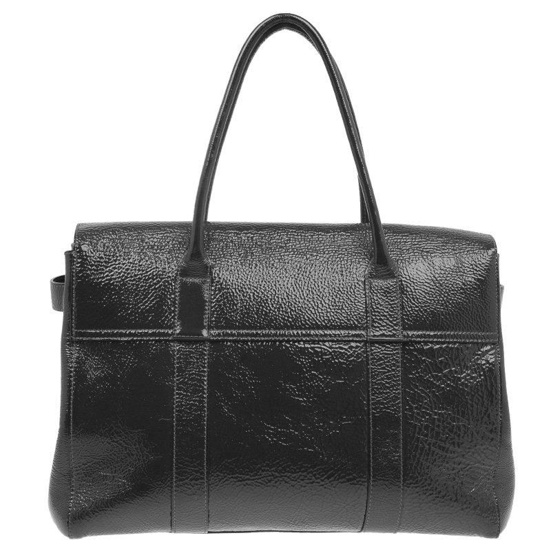 This celebrity coveted Bayswater handbag by Mulberry is timeless. This version is crafted from a dark hued grey patent leather that features the well known Postman’s lock closure in gold-tone hardware, rolled leather handles and a leather tag. The