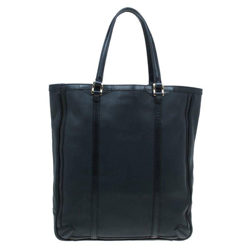 Burberry's classic tote bag will be your favorite carry-all bag for the day. Made from perforated leather and accented with smooth leather trims it features double flat handles. Secured with a top snap closure the spacious fabric-lined interior